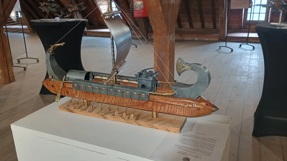 Sculpture de bateau à voile en bois et métal présentée lors d’une exposition