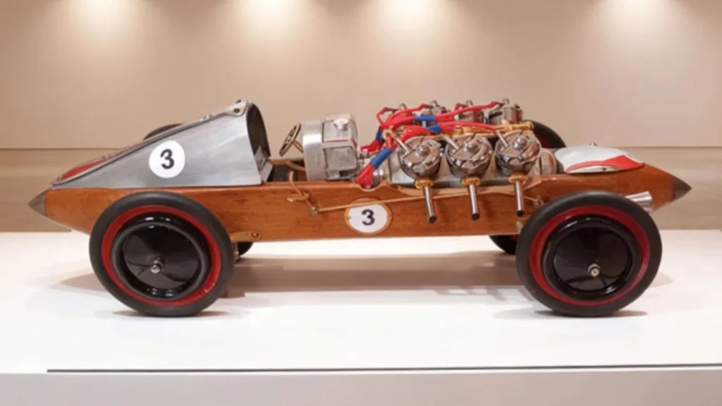Sculpture voiture en métal recyclé avec carrosserie en navette de filage ancienne