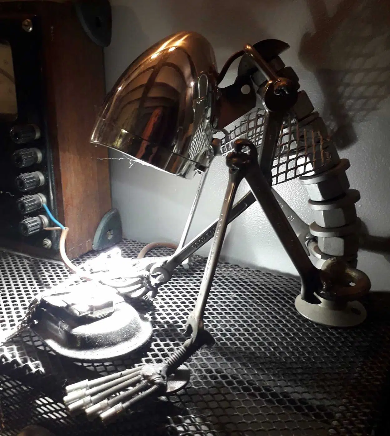 Lampe sculpture bonhomme assis en métal recyclé avec ampoule en guise de tête