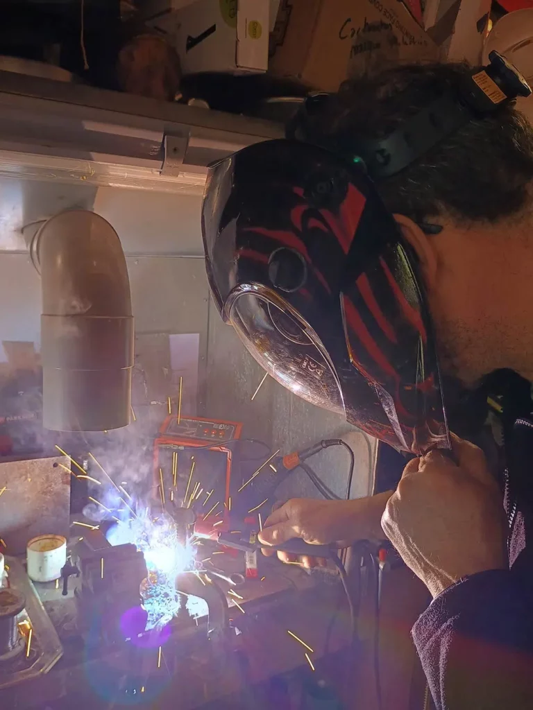 Bruno Cotton en plein travail de soudure pour une sculpture en métal recyclé
