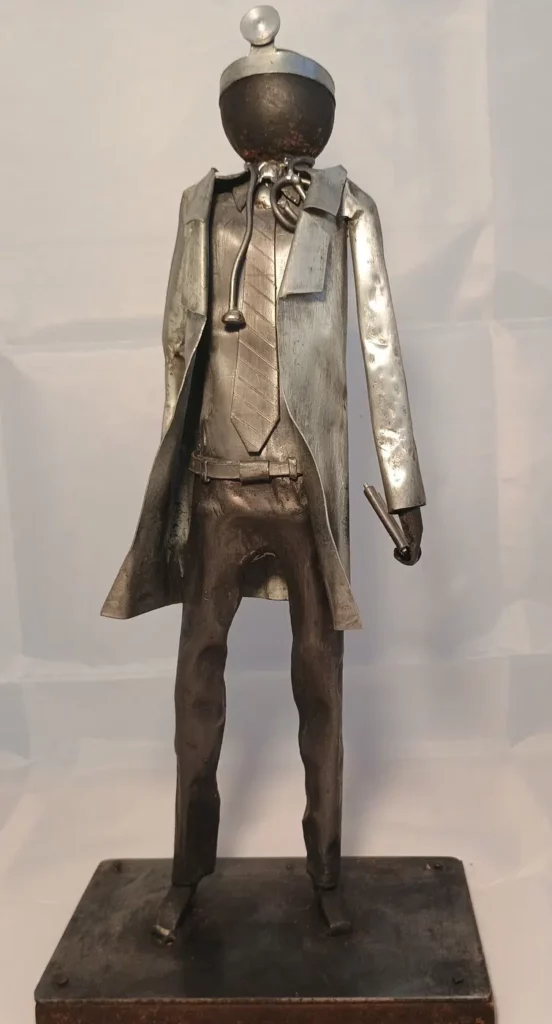 Sculpture médecin en métal recyclé avec blouse stylisée, stéthoscope et détails en cuivre