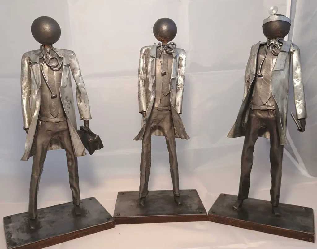 Sculpture médecin en métal recyclé avec blouse stylisée, stéthoscope et détails en cuivre