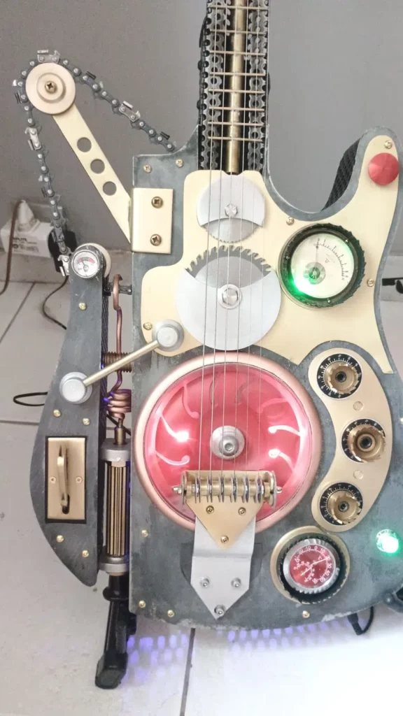 Guitare artistique en métal recyclé avec chaînes, disques et carter industriel