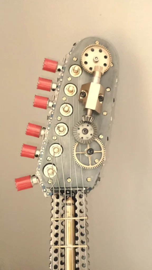 Guitare artistique en métal recyclé avec chaînes, disques et carter industriel