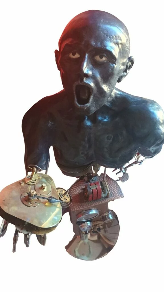 Visage expressif de la sculpture mixte La souffrance de l’homme, accompagné de pièces mécaniques